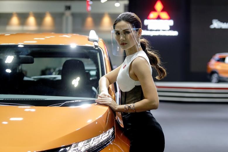 A model wearing a face shield poses with a Mitsubishi vehicle. REUTERS/Jorge Silva
